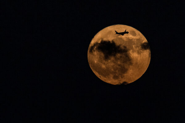 An airliner crosses a supermoon above Israel